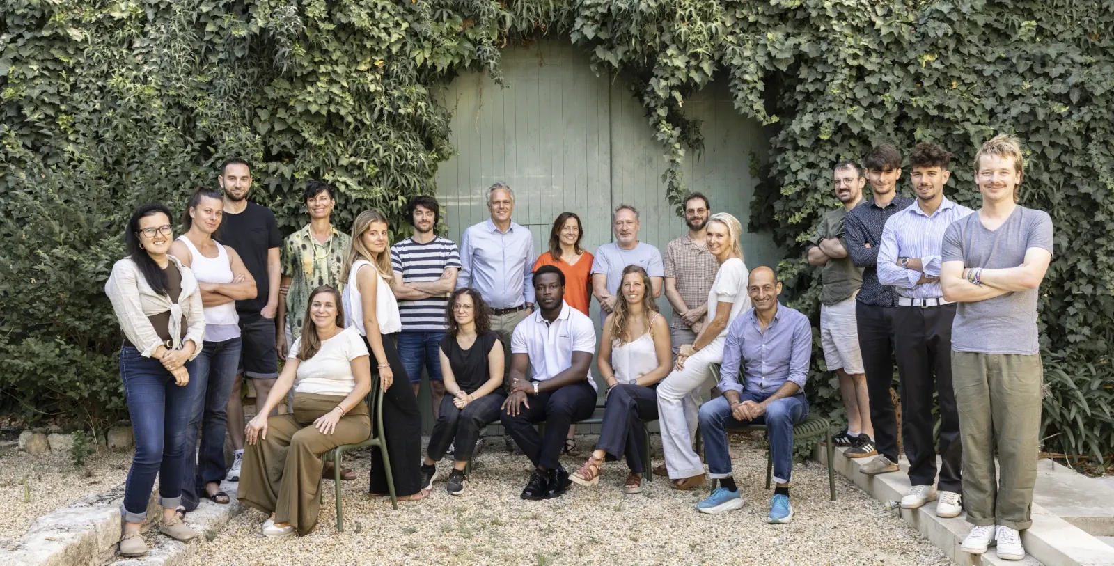 L’équipe de Look Up Geoscience réunie devant une porte entourée de lierre